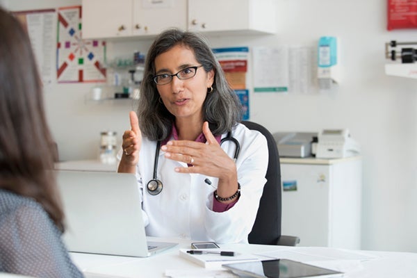 Physician speaking with a patient in a medical office.