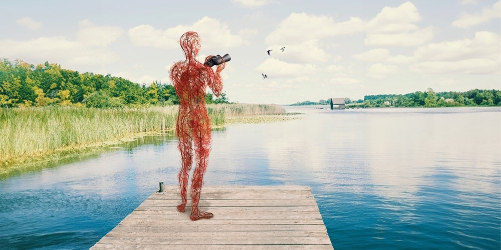 Artery man holding a binocular and watching birds over a serene lake, standing on a wooden dock with lush greenery and a bright, cloudy sky in the background