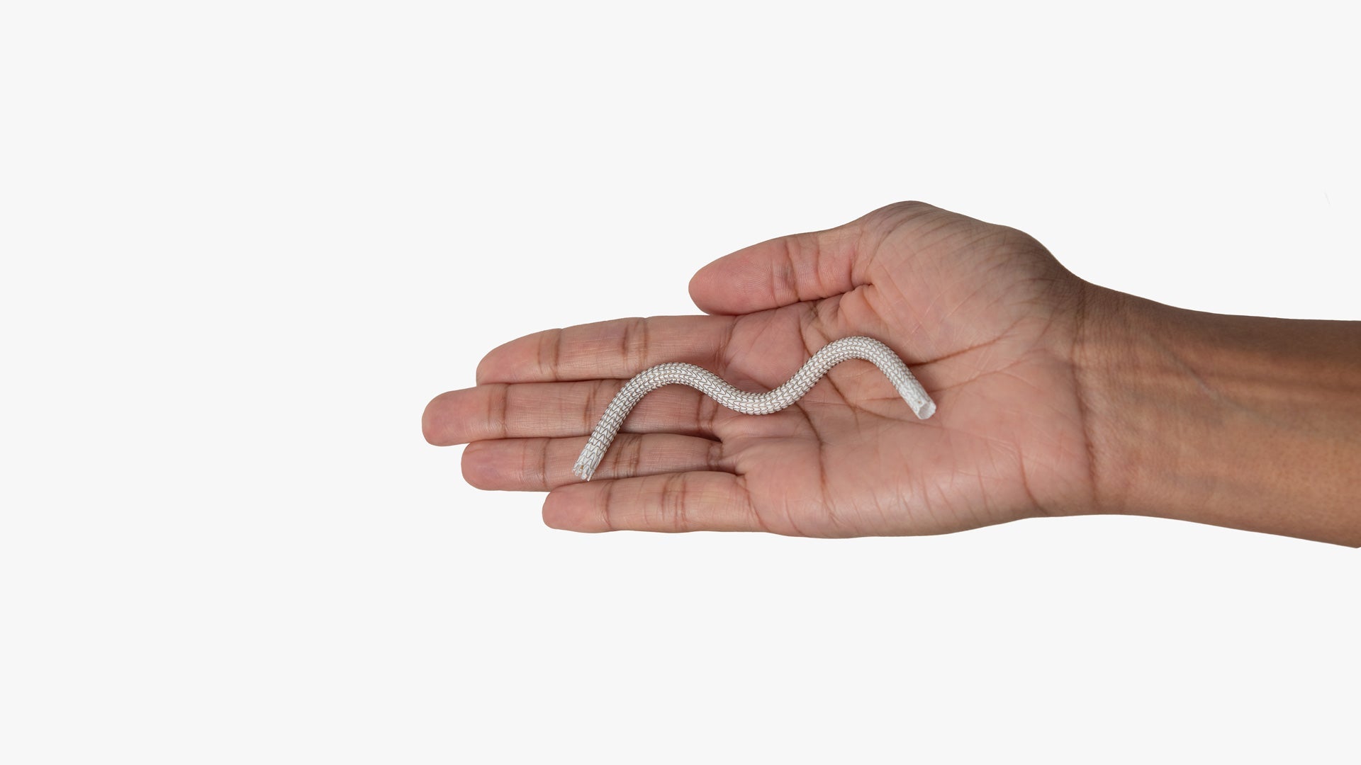 Close-up image of a hand holding the GORE® VIABAHN® Endoprosthesis with PROPATEN Bioactive Surface stent graft device