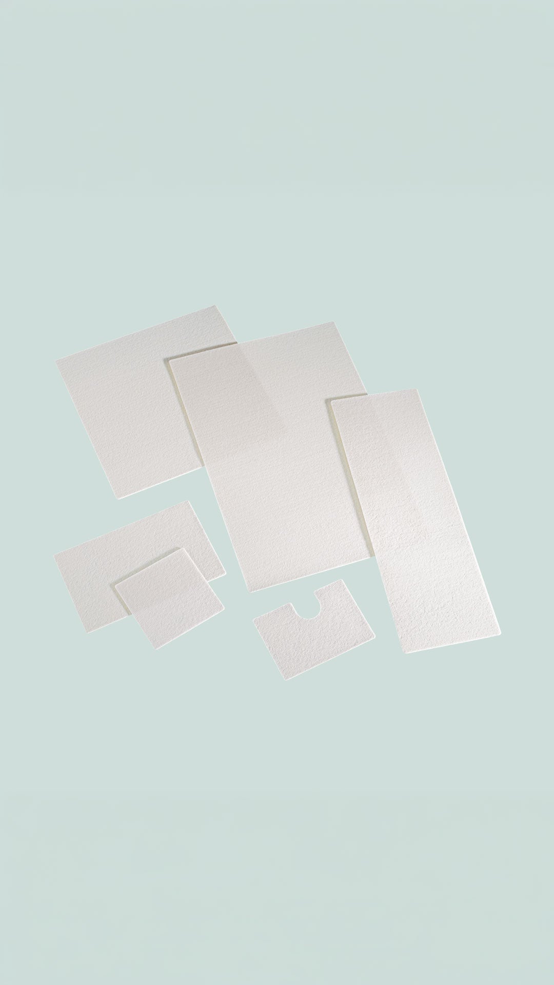 Product image showing multiple sizes and shapes of GORE BIO-A Tissue Reinforcement, including rectangular, square, and notched white porous scaffold sheets arranged on a light blue background.