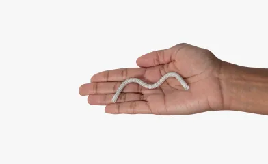 Imagen en primer plano de una mano sosteniendo la endoprótesis GORE® VIABAHN® con Superficie Bioactiva PROPATEN