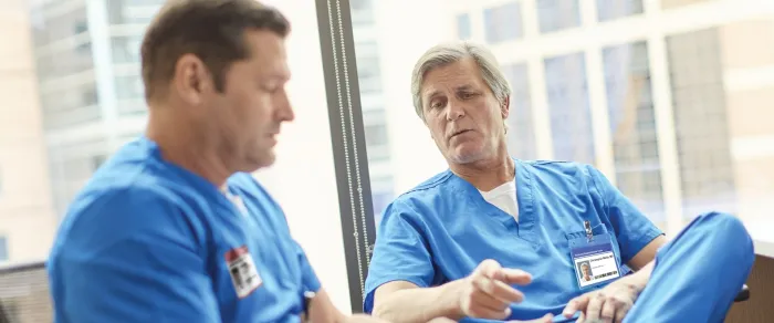 two men in blue scrubs talking