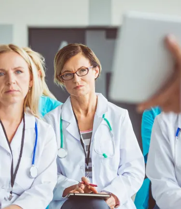 Two fellows looking at presenter with tablet