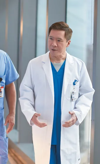 two male physicians walking down a hall talking to each other