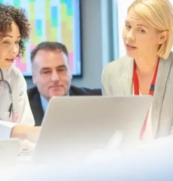 doctors and business people in a meeting looking at a computer