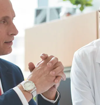 Two health care professionals discussing information at a desk