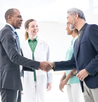 A physician, purchaser and a healthcare professional are having a conversation in a bright room in the hospital