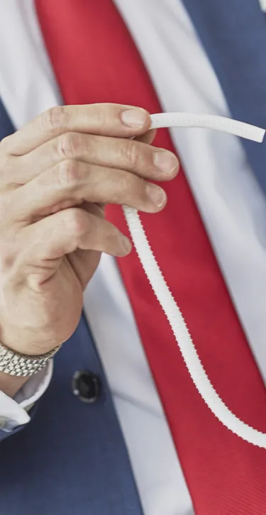 close up of male in suit holding gore medical device material